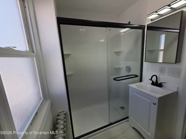 a bathroom with a shower sink and mirror