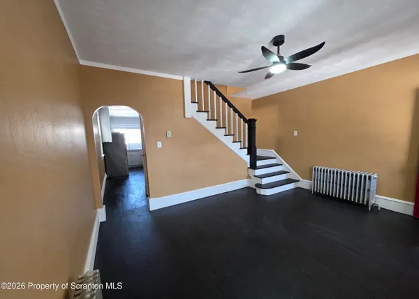 a view of a livingroom with wooden floor and staircase