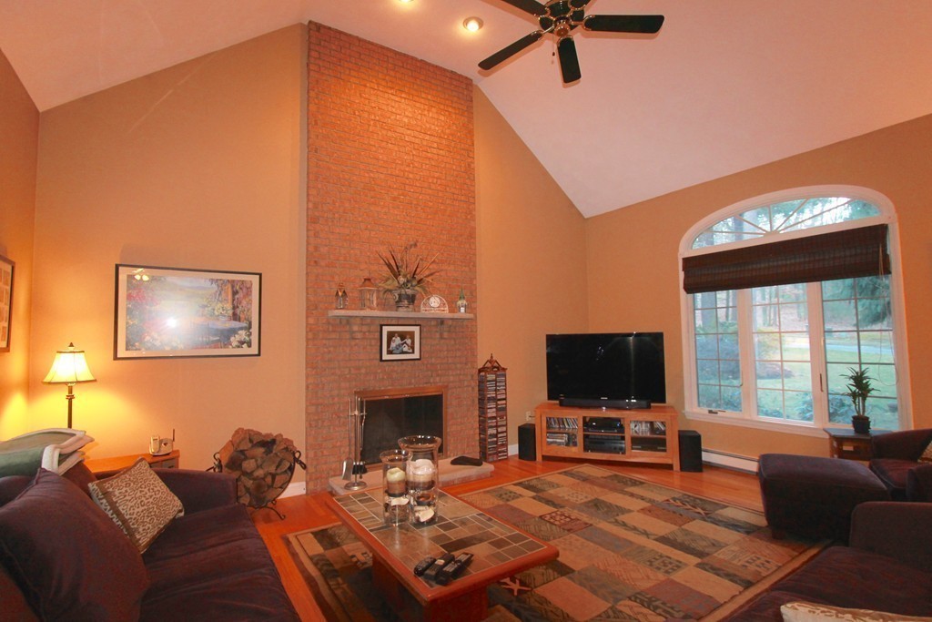 106 Flint Farm Road Middleton, MA 01949 - Photo 12 of 30 a living room with furniture a flat screen tv and a fireplace