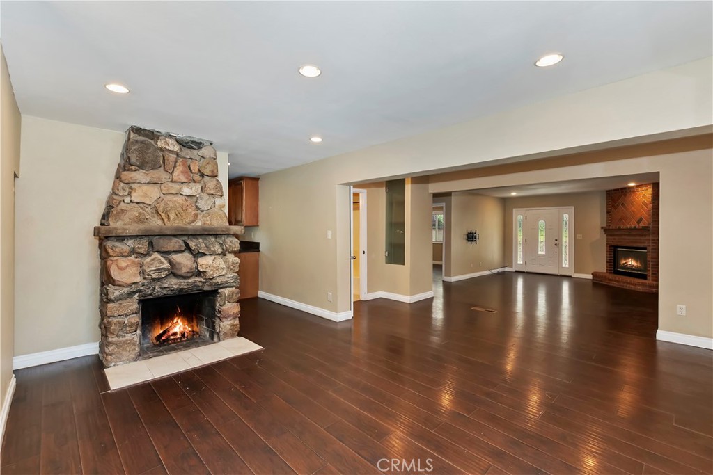 23739 Hillside Drive Crestline, CA 92325 - Photo 13 of 37 a view of an empty room with wooden floor fireplace and a window