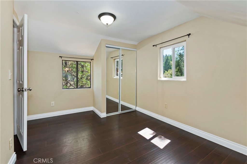23739 Hillside Drive Crestline, CA 92325 - Photo 26 of 37 an empty room with wooden floor and windows