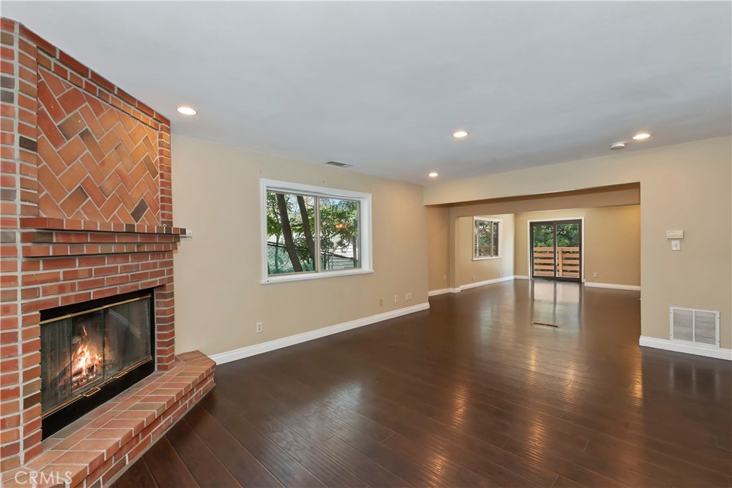 23739 Hillside Drive Crestline, CA 92325 - Photo 6 of 37 a view of an empty room with wooden floor fireplace and a window