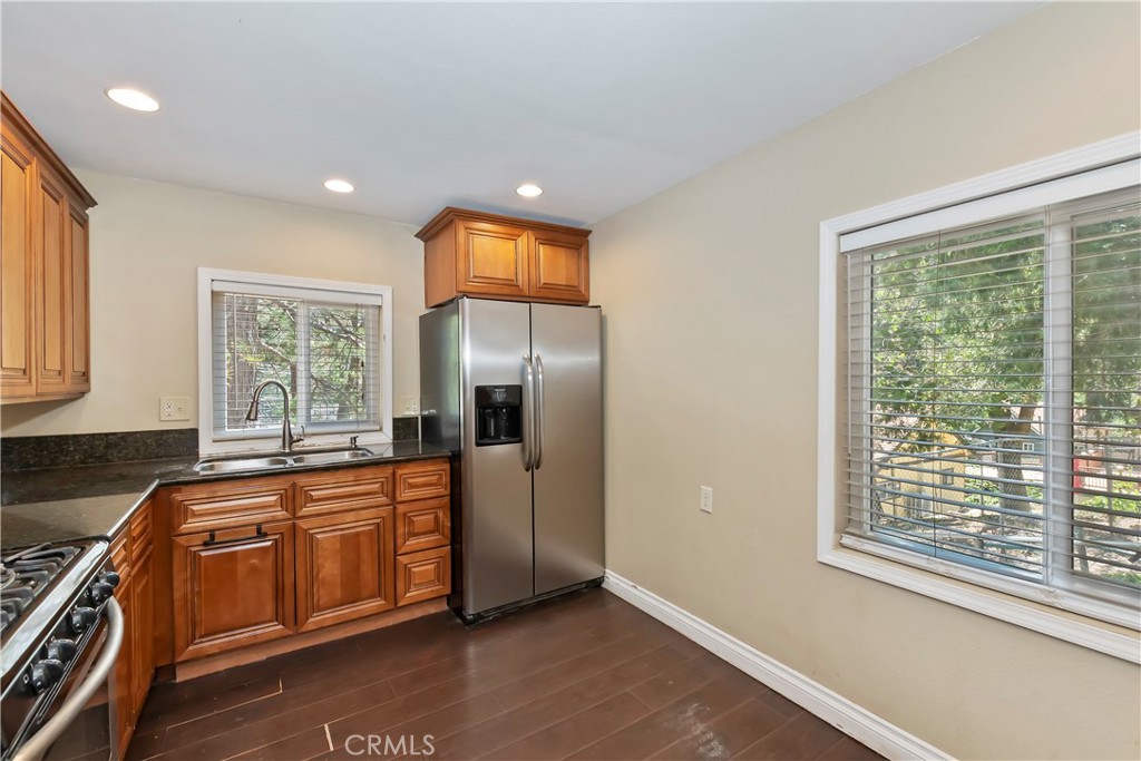 23739 Hillside Drive Crestline, CA 92325 - Photo 8 of 37 a large kitchen with stainless steel appliances granite countertop a sink and a dishwasher next to a large window