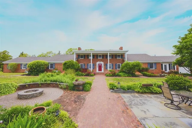a view of multiple houses with yard and green space