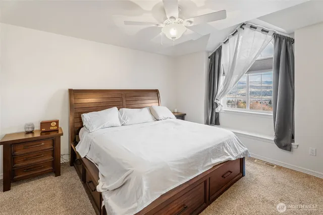a bedroom with a bed and a flat tv screen on dresser