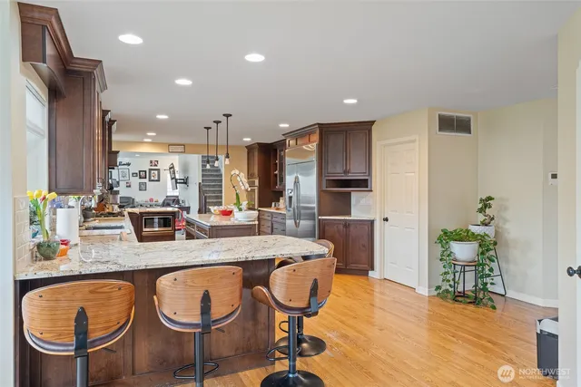 a dining room with furniture potted plants and wooden floor