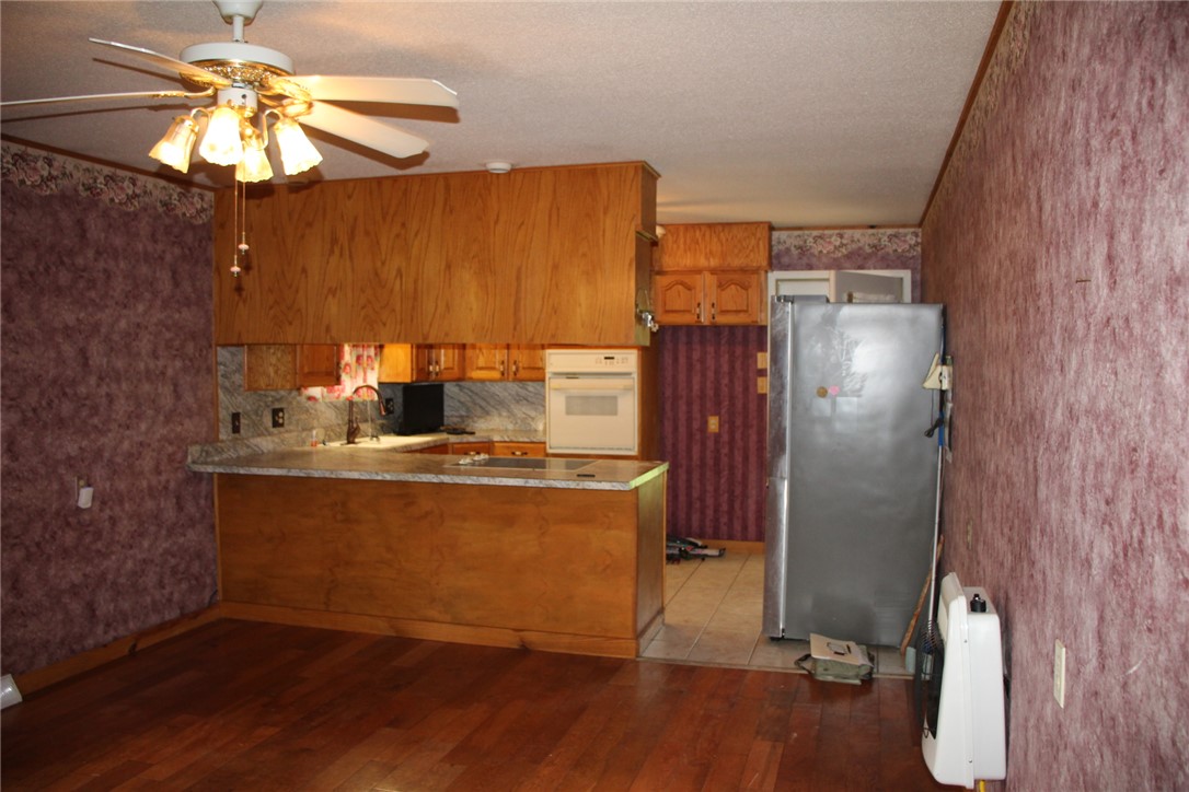 402 Canaan Road Marshall, AR 72650 - Photo 11 of 37 Kitchen featuring wood-finish cabinetry, light-toned countertops, and a built-in oven
