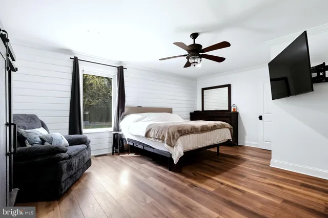 a bedroom with a bed a flat screen tv and a couch