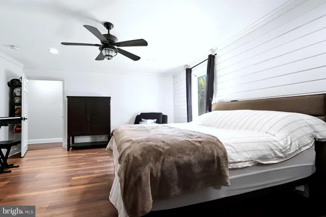a bedroom with a bed and a flat tv screen on dresser
