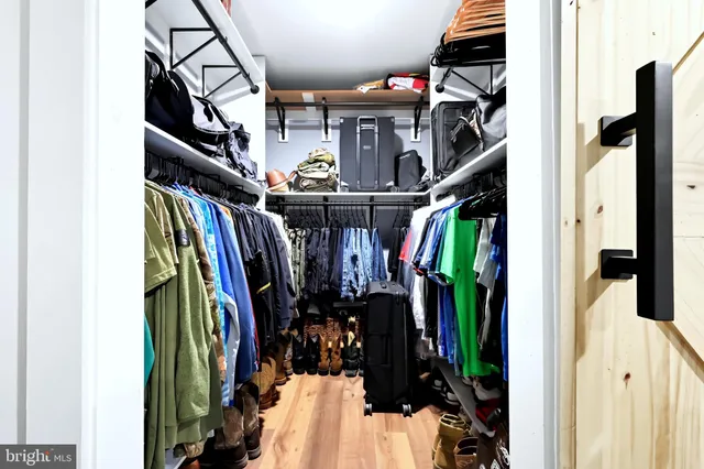 a view of walk in closet with clothes and shoes