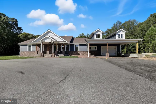 a front view of a house with a yard and lake view