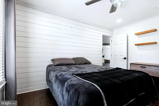 a bedroom with a bed and a ceiling fan