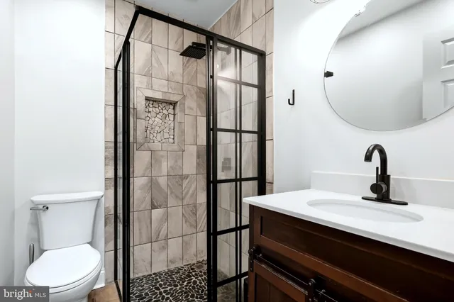 a bathroom with a sink a toilet and shower