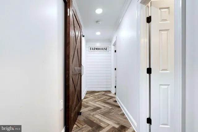 a view of hallway with walk in closet and wooden floor