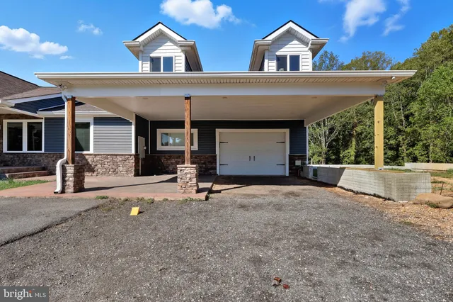 front view of house with a yard and potted plants