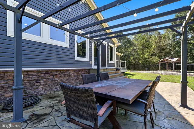 a view of a patio with table and chairs with wooden floor and fence