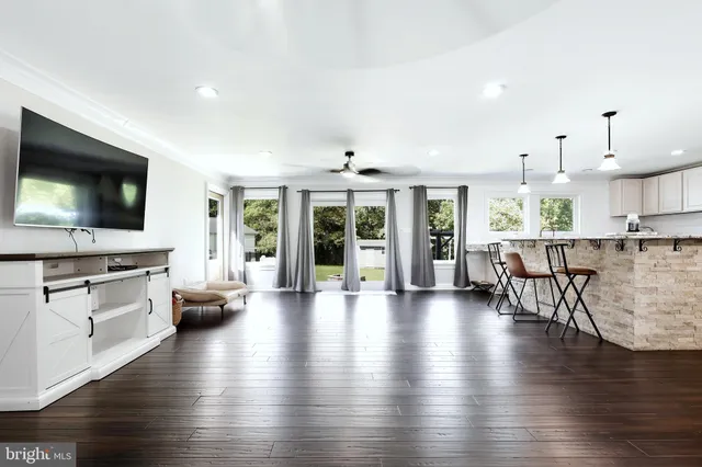 a living room with furniture wooden floor and a flat screen tv