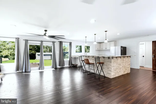 an open kitchen with white cabinets and wooden floor