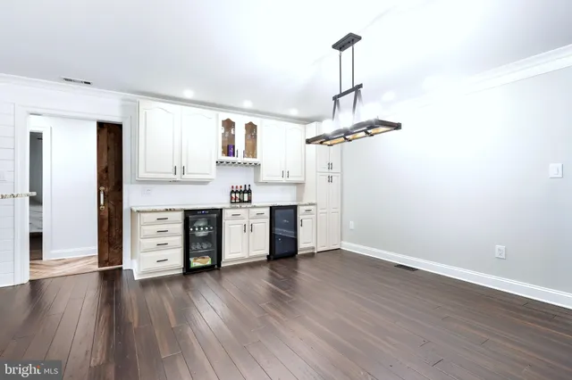 a kitchen with stainless steel appliances a kitchen island hardwood floor and a sink