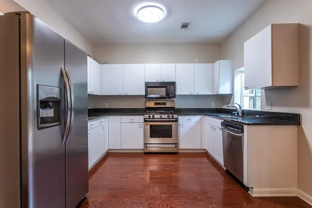 a kitchen with granite countertop a sink stove and refrigerator
