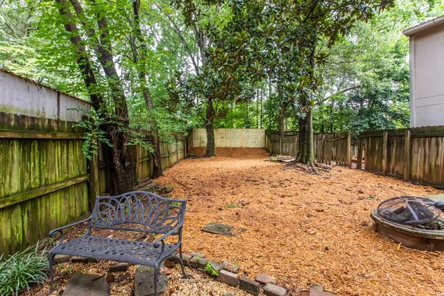 a view of a patio with table and chairs with wooden floor and fence