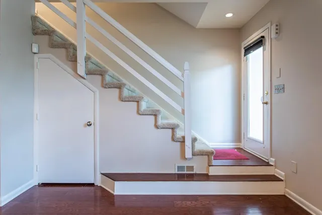 a view of a livingroom with a fireplace a chandelier and wooden floor