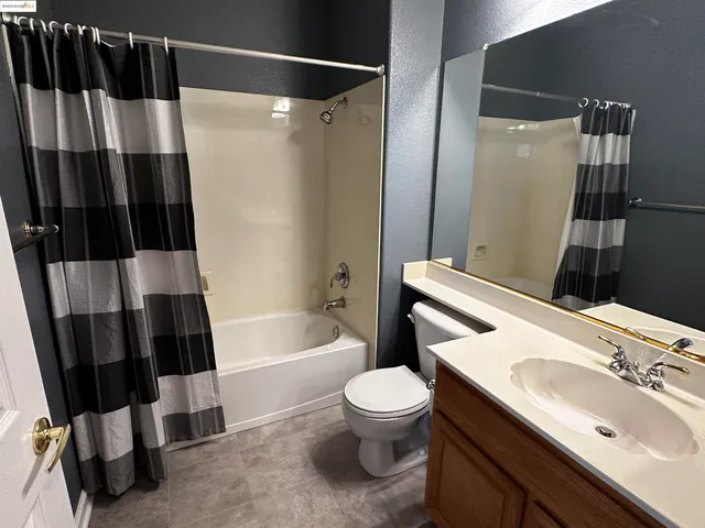 a bathroom with a sink a toilet a tub and shower