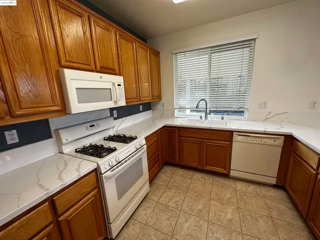a kitchen with a sink stove top oven and cabinets