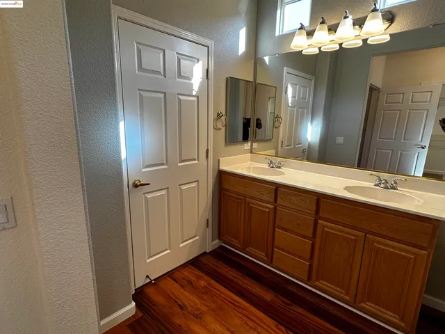 a spacious bathroom with a double vanity sink a mirror and a shower