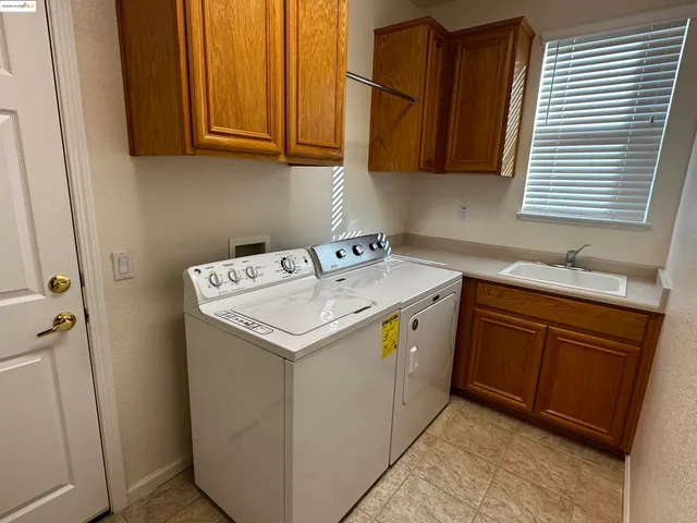 a utility room with sink dryer and washer