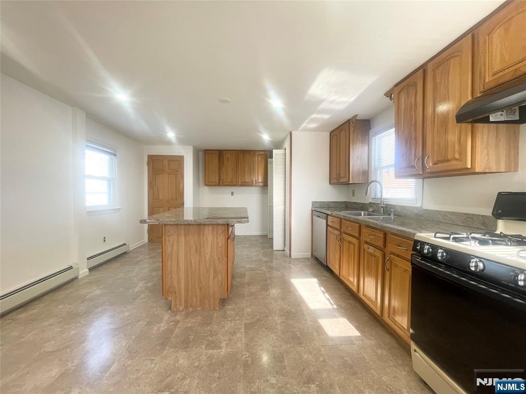 169 Magnolia Avenue, Unit 2 3 Kearny, NJ 07032 - Photo 14 of 23 a kitchen with stainless steel appliances granite countertop a stove a sink a refrigerator white cabinets and a refrigerator