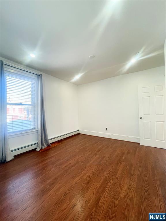169 Magnolia Avenue, Unit 2 3 Kearny, NJ 07032 - Photo 16 of 23 an empty room with wooden floor and windows