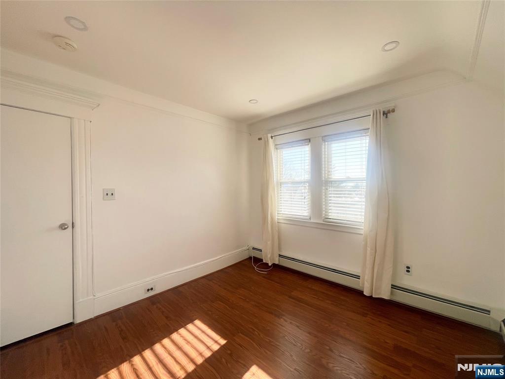 169 Magnolia Avenue, Unit 2 3 Kearny, NJ 07032 - Photo 22 of 23 an empty room with wooden floor and windows