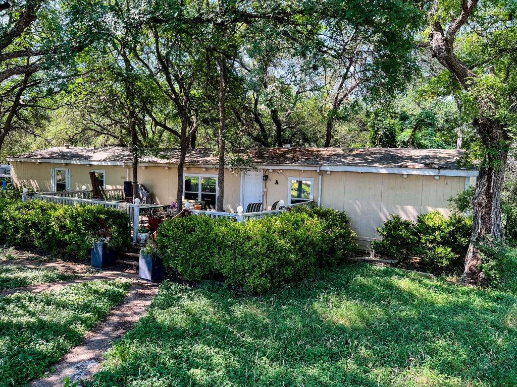 a view of a house with a yard and a large tree