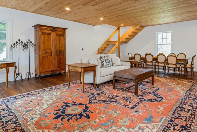 a living room with patio furniture and a wooden floor