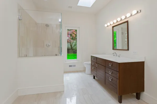 a spacious bathroom with a tub sink and mirror