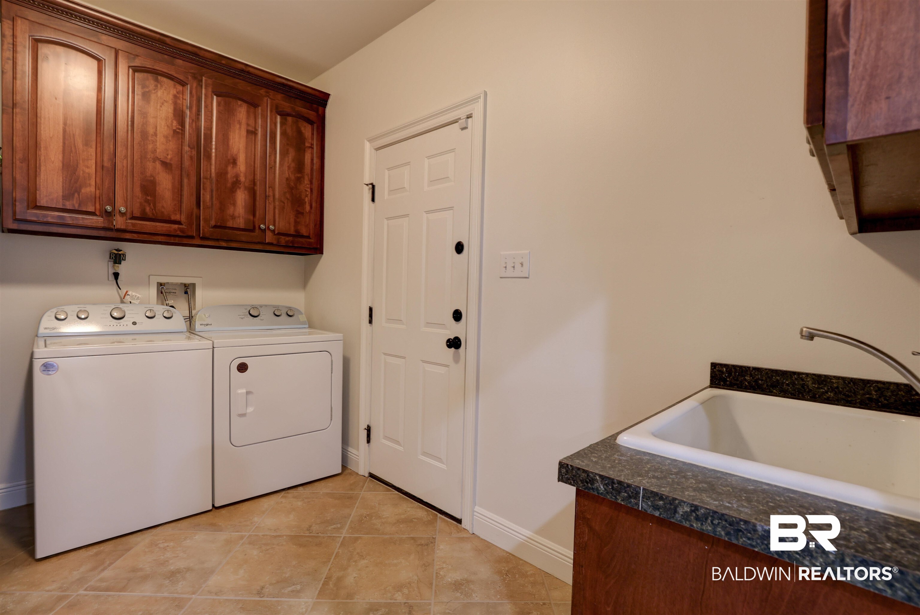 5565 Dawes Lane Theodore, AL 36582 - Photo 24 of 38 Laundry area featuring light tile patterned floors, cabinets, washing machine and clothes dryer, and sink