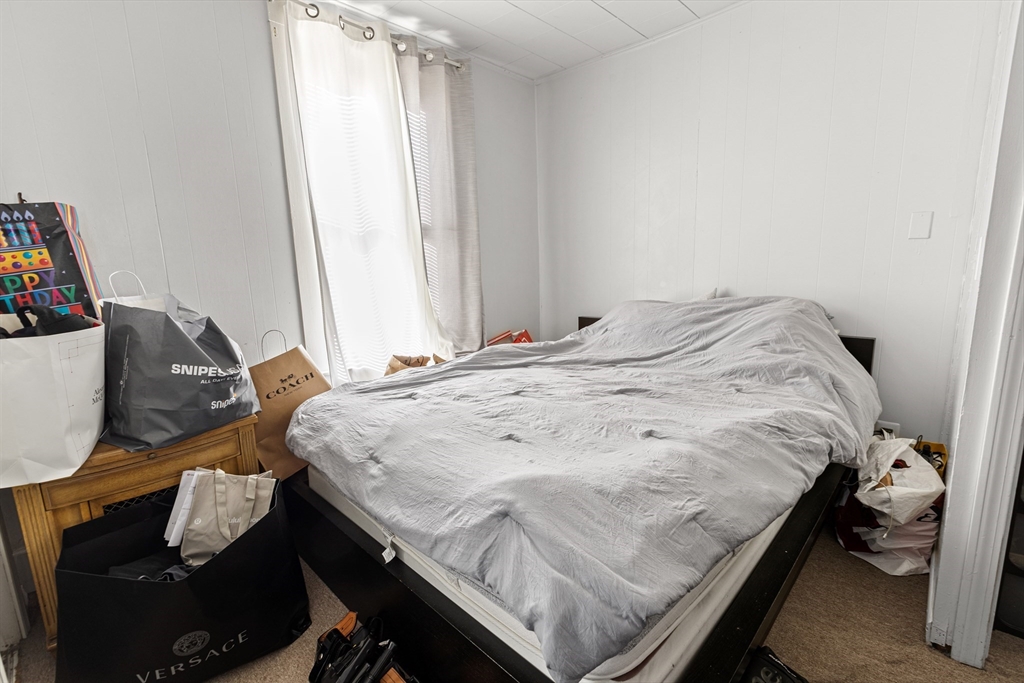 62-66 Butler Street Lawrence, MA 01841 - Photo 11 of 37 a bed sitting in a bedroom next to a window