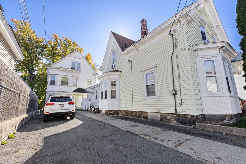 62-66 Butler Street Lawrence, MA 01841 - Photo 2 of 37 a car parked in front of a white house