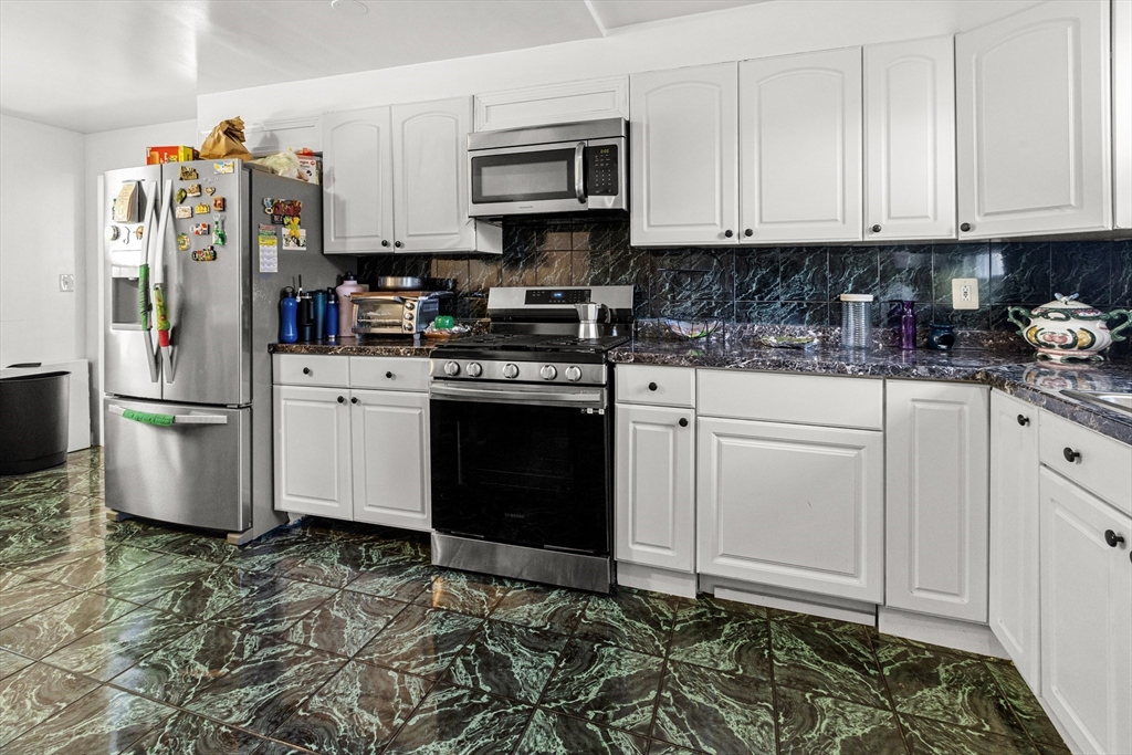 62-66 Butler Street Lawrence, MA 01841 - Photo 21 of 37 a kitchen with stainless steel appliances granite countertop a refrigerator sink and cabinets