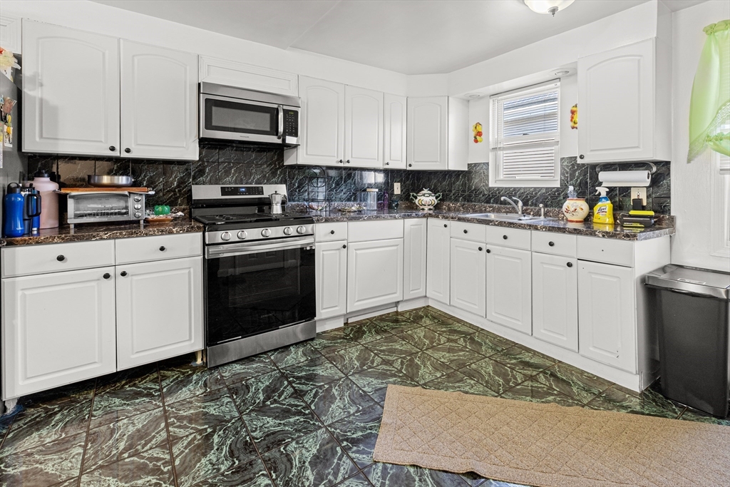 62-66 Butler Street Lawrence, MA 01841 - Photo 29 of 37 a kitchen with stainless steel appliances granite countertop a stove a sink and white cabinets