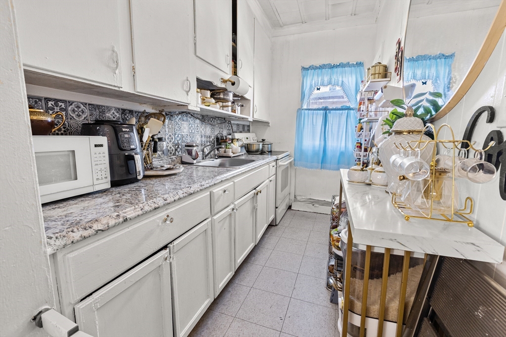 62-66 Butler Street Lawrence, MA 01841 - Photo 8 of 37 a kitchen with stainless steel appliances granite countertop a sink and stove
