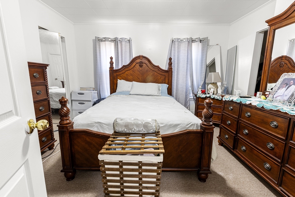 62-66 Butler Street Lawrence, MA 01841 - Photo 10 of 37 a bedroom with a bed and wooden floor