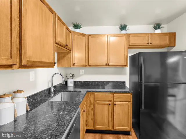 a kitchen with stainless steel appliances granite countertop a refrigerator sink and stove