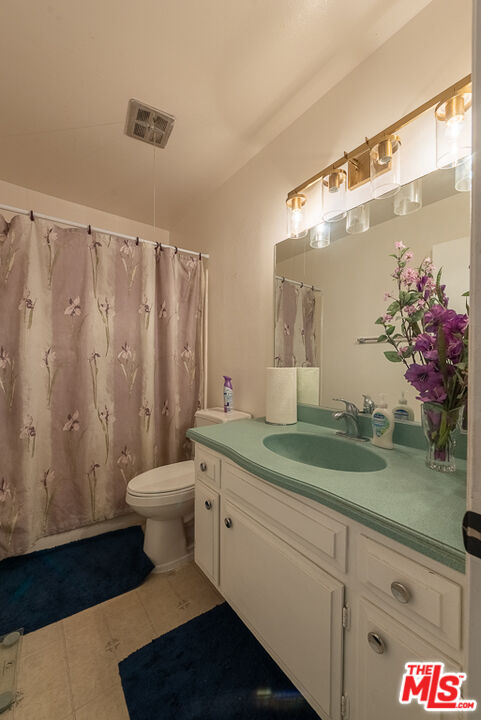 1637 Downing Street Simi Valley, CA 93065 - Photo 11 of 26 a bathroom with a granite countertop sink a toilet and a mirror