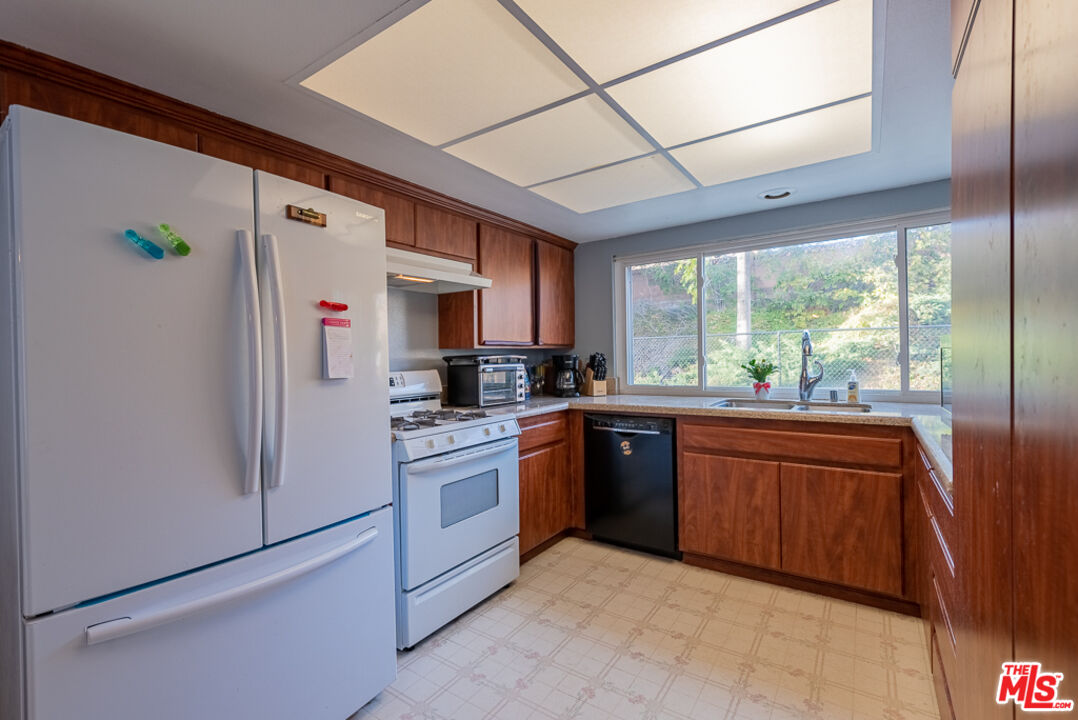 1637 Downing Street Simi Valley, CA 93065 - Photo 12 of 26 a kitchen with stainless steel appliances granite countertop a refrigerator a sink dishwasher a stove top oven and a dining table