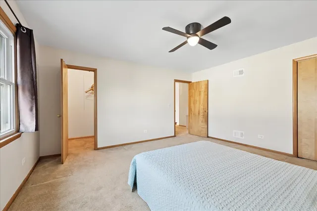 a bedroom with a bed and a ceiling fan