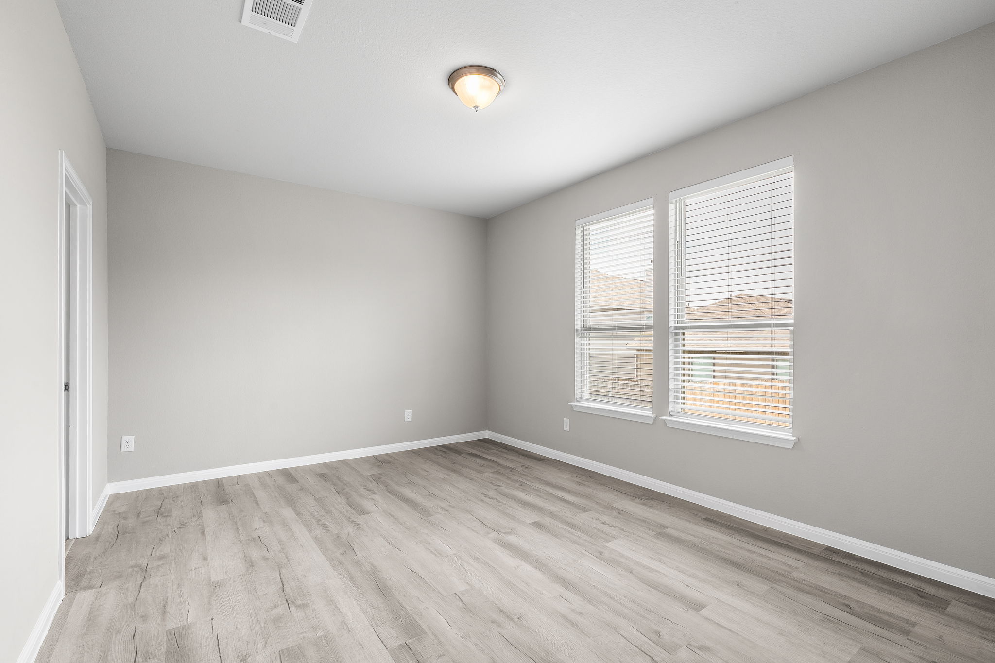 313 Mclintock Road Jarrell, TX 76537 - Photo 23 of 40 A well-lit, neutral-toned room features durable wood flooring and ample natural illumination from multiple windows.