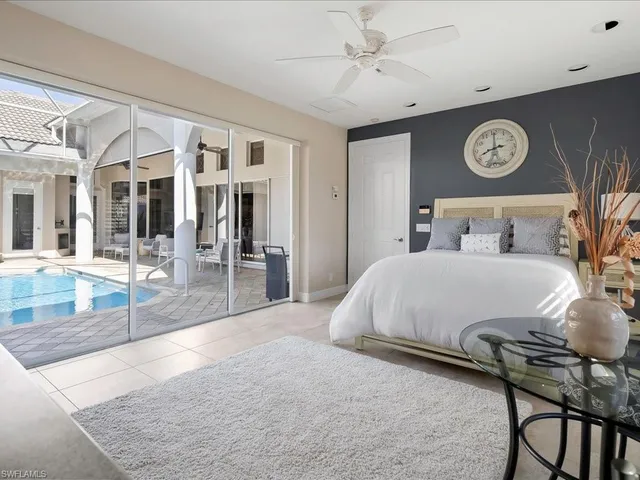 a spacious bedroom with a bed and glass walk in closet