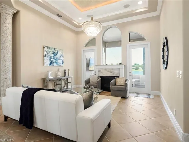 a living room with furniture a fireplace and a chandelier